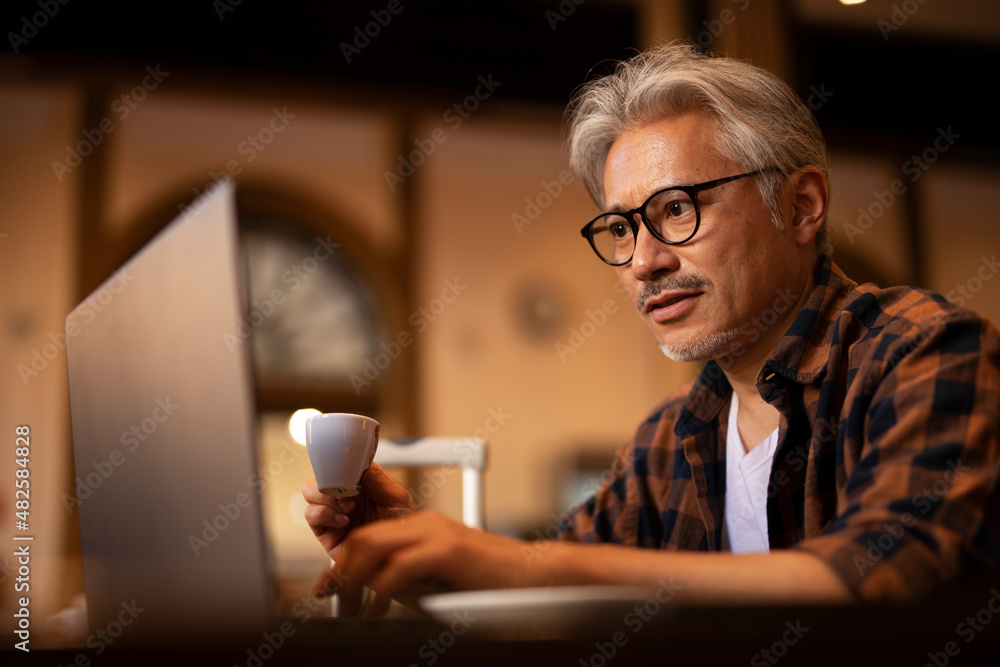 Businessman working on laptop in cafe. Handsome senior man enjoying in fresh coffee. Businessman working on laptop in cafe. Handsome senior man enjoying in fresh coffee.