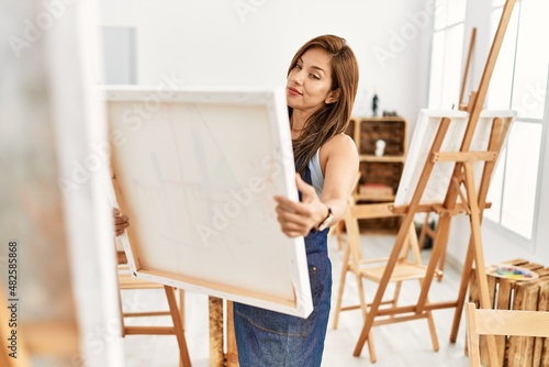 Young hispanic artist woman smiling happy drawing at art studio.
