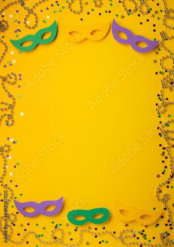 Fotografiet Mardi Gras gold color beads with Masquerade festival carnival masks and golden, green, purple confetti on yellow background