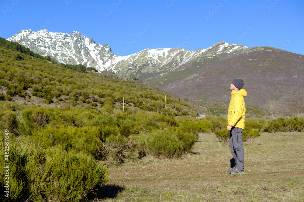 A man observes the snow-capped mountains in winter. Health and energy in nature