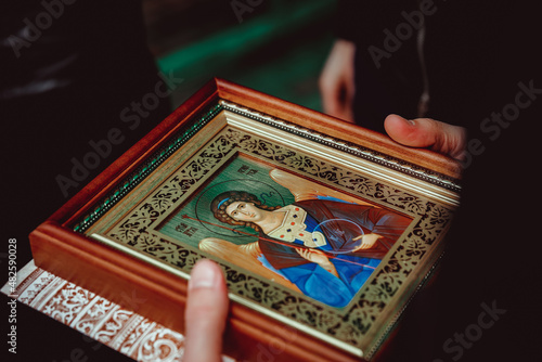 a woman holds an Orthodox icon of the guardian angel in her hands Fototapeta