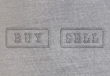 Buy and sell buttons on a brushed aluminum sheet metal. Commodity trading concept.