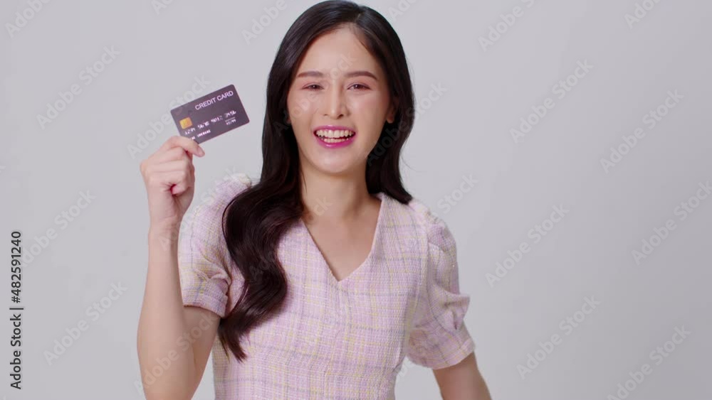 Happy attractive asian young woman hold credit card for shopping and paying smile isolated on white background.Cheerful pretty girl use banking credit card for online shopping spending bonus cashback Happy attractive asian young woman hold credit card for shopping and paying smile isolated on white background.Cheerful pretty girl use banking credit card for online shopping spending bonus cashback