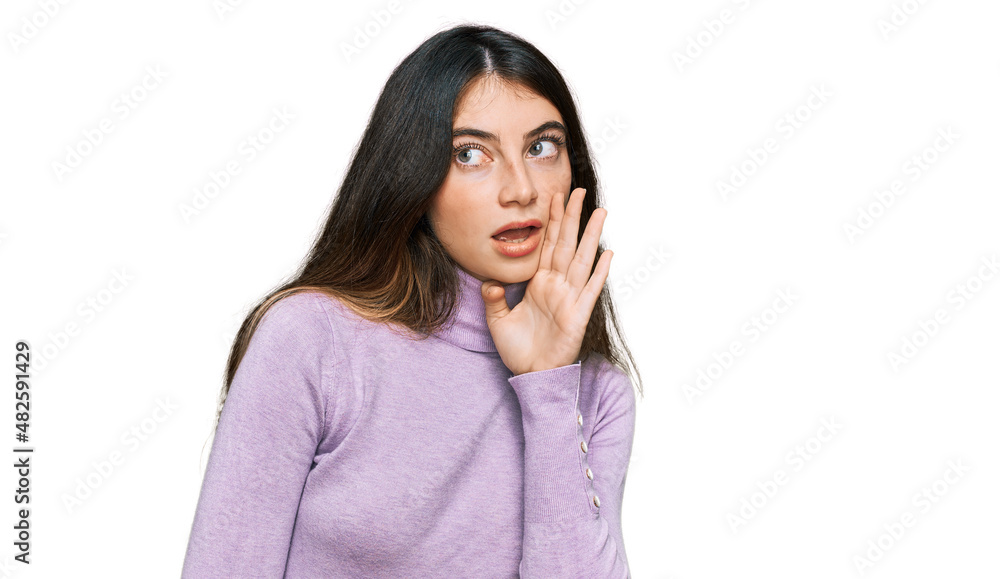Young beautiful teen girl wearing turtleneck sweater hand on mouth telling secret rumor, whispering malicious talk conversation Young beautiful teen girl wearing turtleneck sweater hand on mouth telling secret rumor, whispering malicious talk conversation
