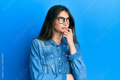 Obraz na plátně Young caucasian woman wearing casual clothes and glasses thinking concentrated a