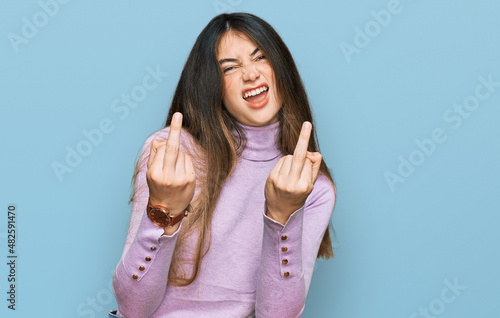Obraz na płótnie Young beautiful teen girl wearing turtleneck sweater showing middle finger doing fuck you bad expression, provocation and rude attitude