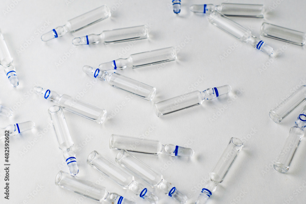 randomly lying ampoules with medicines on a white background randomly lying ampoules with medicines on a white background