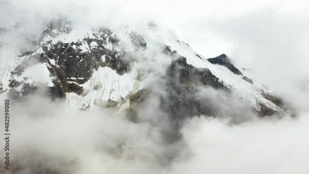 Cinematic drone shot of the Andes Mountains in South America, flying toward the half cloud covered mountain face Cinematic drone shot of the Andes Mountains in South America, flying toward the half cloud covered mountain face
