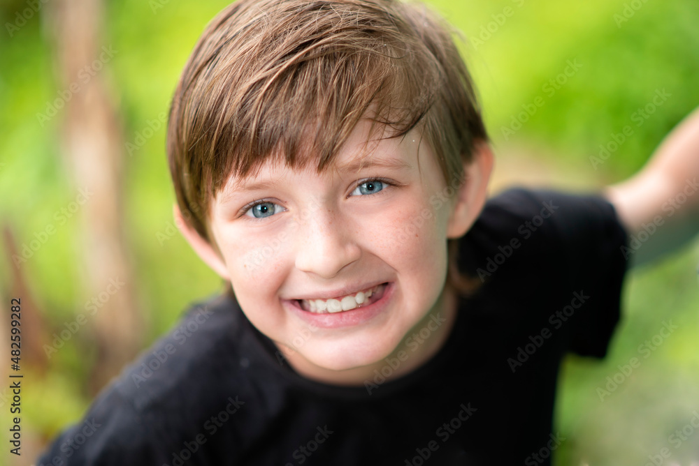 portrait of smiling european happy boy. outside on a green background portrait of smiling european happy boy. outside on a green background
