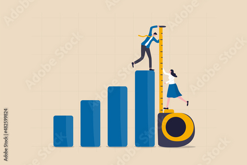 Business benchmark measurement, KPI, key performance indicator to evaluate success, improvement or business growth concept, businessman and woman help using measuring tape to measure bar graph. photo