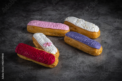 Sweet and colorful eclair on black background. french eclair. top view