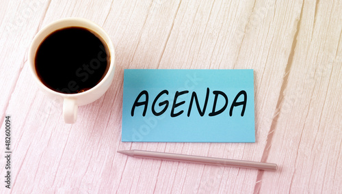 AGENDA text on the blue sticker with cofee and pen