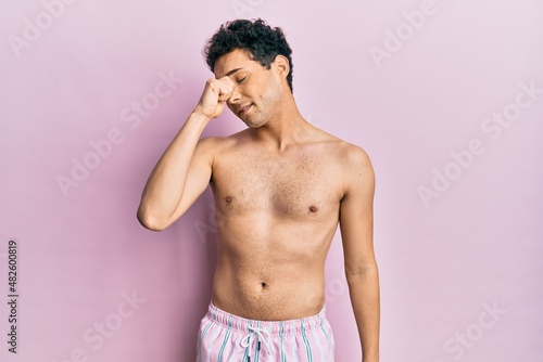 Young handsome man wearing swimwear shirtless tired rubbing nose and eyes feeling fatigue and headache. stress and frustration concept.
