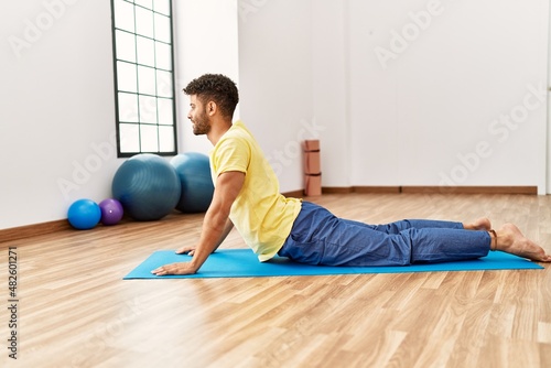 Young arab sporty man smiling happy training yoga at sport center.