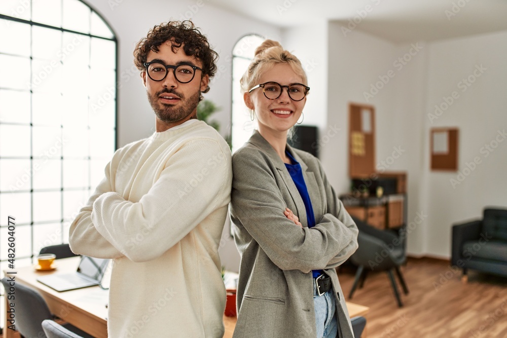 Fototapeta premium Two business workers smiling happy standing with arms crossed gesture at the office.