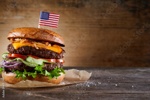 Burger with American flag skewer on table