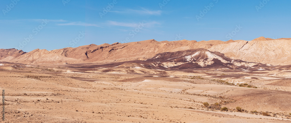 panorama of the bottom of the northwest side of the Maktesh Ramon erosion crater in the Negev desert in Israel with a blue sky background