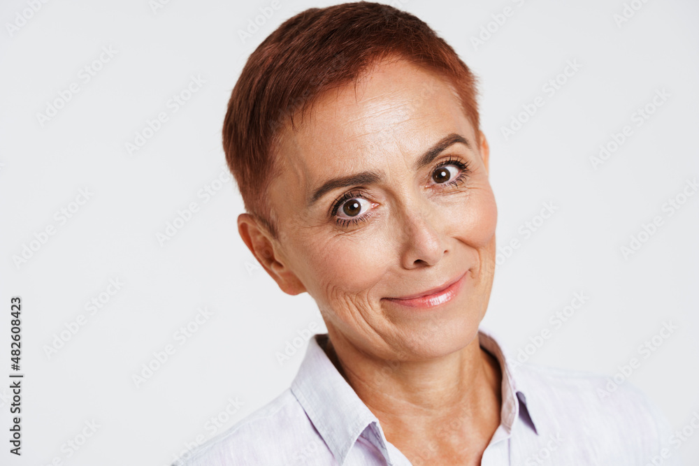 Ginger senior woman with short hair smiling and looking at camera Ginger senior woman with short hair smiling and looking at camera