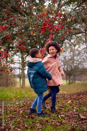 Two Children Enjoy Fall Or Winter Walk In Countryside In Snow
