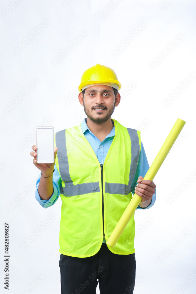 Young engineer showing smartphone screen on white background. Young engineer showing smartphone screen on white background.