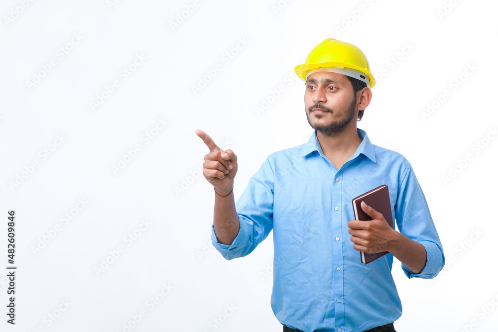 Young indian engineer or student wearing hardhat on white background. Young indian engineer or student wearing hardhat on white background.