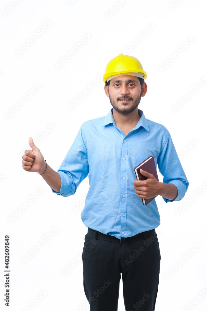 Young indian engineer or student wearing hardhat on white background. Young indian engineer or student wearing hardhat on white background.