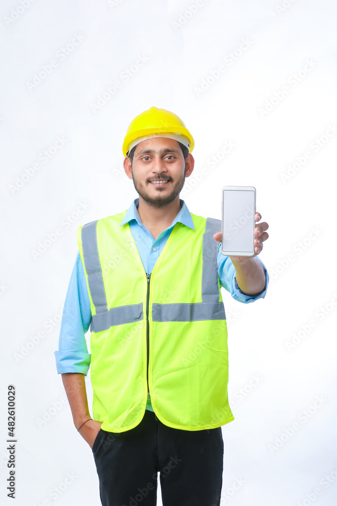 Young engineer showing smartphone screen on white background. Young engineer showing smartphone screen on white background.