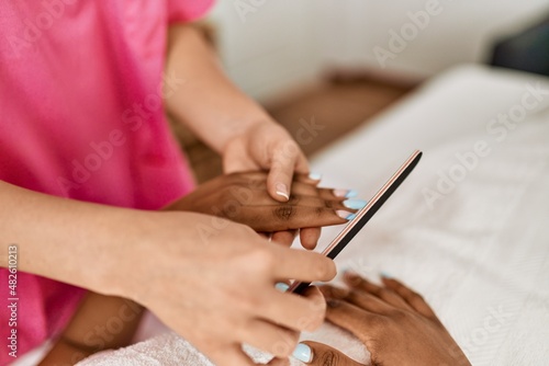 Young african american woman having manicure session at beauty center