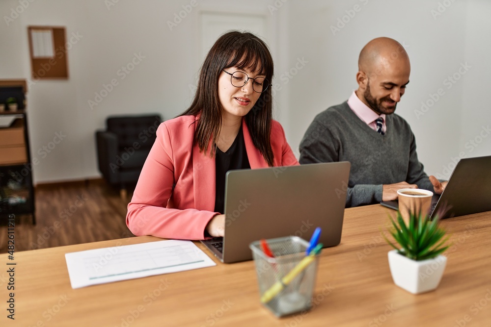 Two hispanic business workers smiling happy working at the office. Two hispanic business workers smiling happy working at the office.