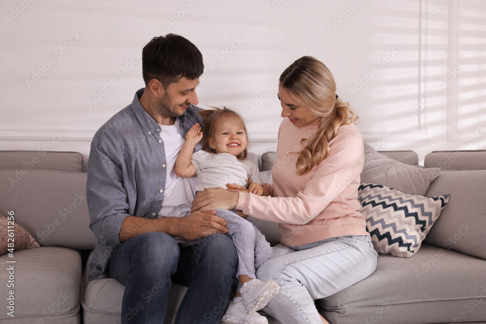 Family with little daughter spending time together on sofa at home Family with little daughter spending time together on sofa at home