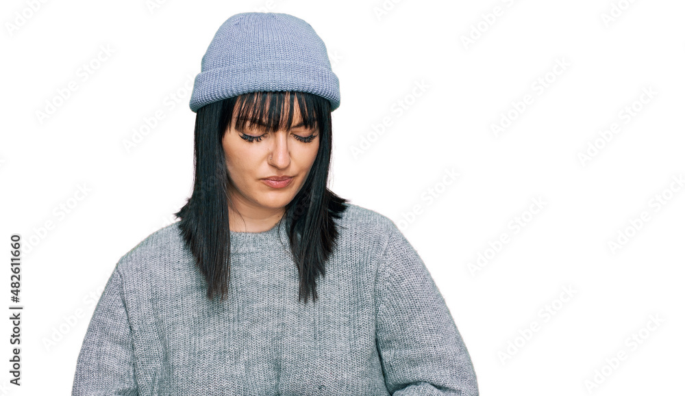 Young hispanic woman wearing cute wool cap with hand on stomach because indigestion, painful illness feeling unwell. ache concept. Young hispanic woman wearing cute wool cap with hand on stomach because indigestion, painful illness feeling unwell. ache concept.