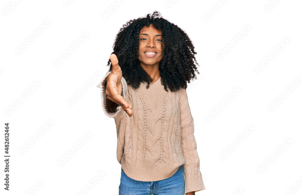 Young african american girl wearing casual clothes smiling friendly offering handshake as greeting and welcoming. successful business. Young african american girl wearing casual clothes smiling friendly offering handshake as greeting and welcoming. successful business.