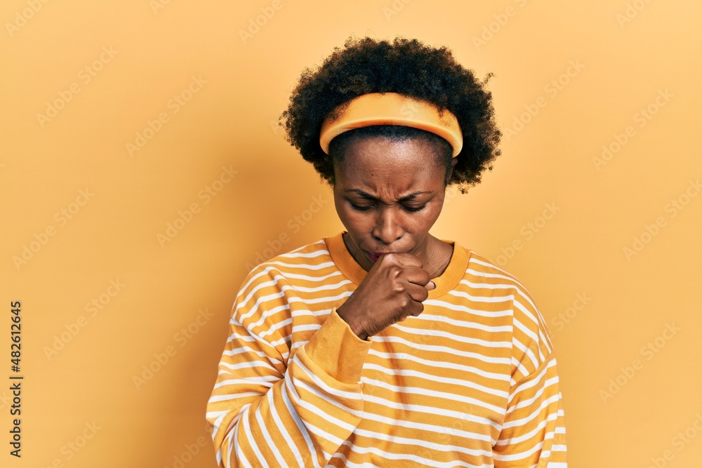 Young african american woman wearing casual sweatshirt feeling unwell and coughing as symptom for cold or bronchitis. health care concept. Young african american woman wearing casual sweatshirt feeling unwell and coughing as symptom for cold or bronchitis. health care concept.