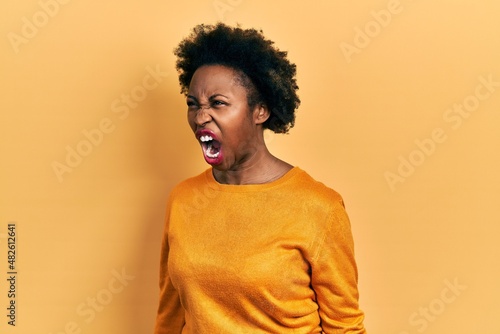 Young african american woman wearing casual clothes angry and mad screaming frustrated and furious, shouting with anger. rage and aggressive concept. © Krakenimages.com
