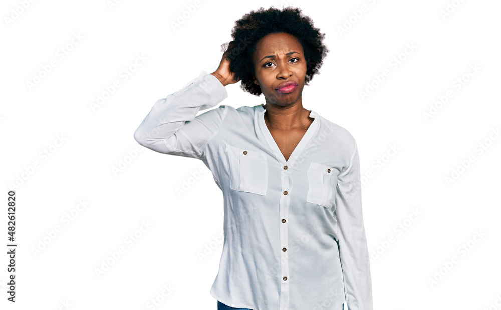 African american woman with afro hair wearing casual white t shirt confuse and wonder about question. uncertain with doubt, thinking with hand on head. pensive concept. African american woman with afro hair wearing casual white t shirt confuse and wonder about question. uncertain with doubt, thinking with hand on head. pensive concept.