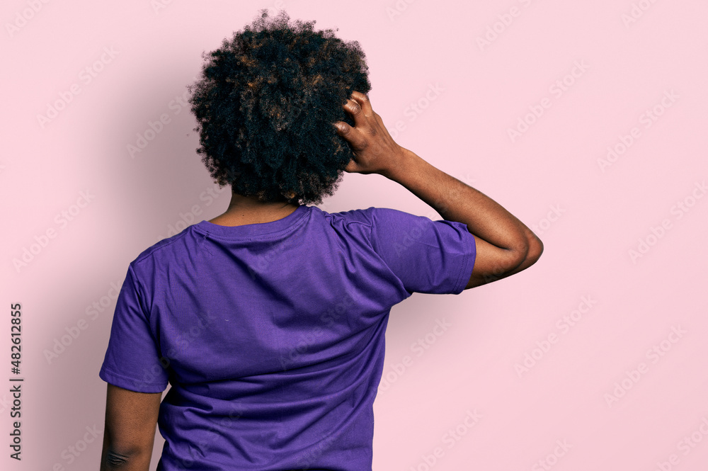 African american woman with afro hair wearing casual purple t shirt backwards thinking about doubt with hand on head African american woman with afro hair wearing casual purple t shirt backwards thinking about doubt with hand on head
