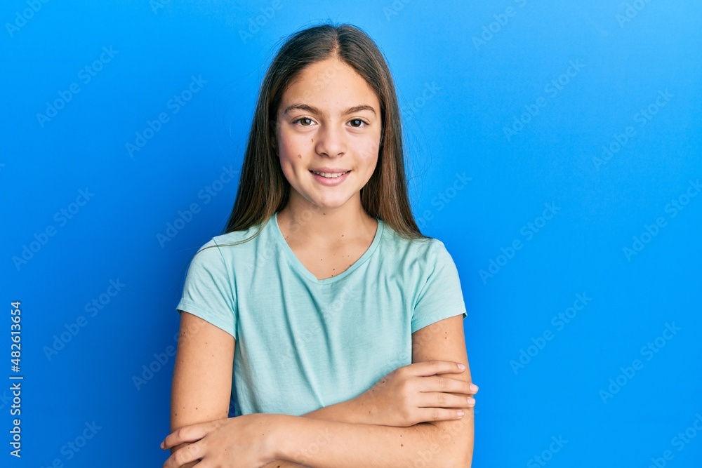 Beautiful brunette little girl wearing casual white t shirt happy face smiling with crossed arms looking at the camera. positive person. Beautiful brunette little girl wearing casual white t shirt happy face smiling with crossed arms looking at the camera. positive person.