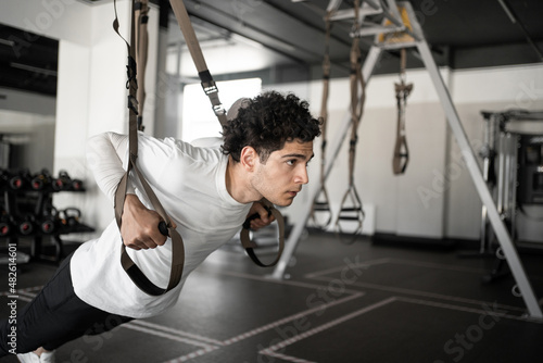 A male athlete does cardio exercises training in the gym © muse studio