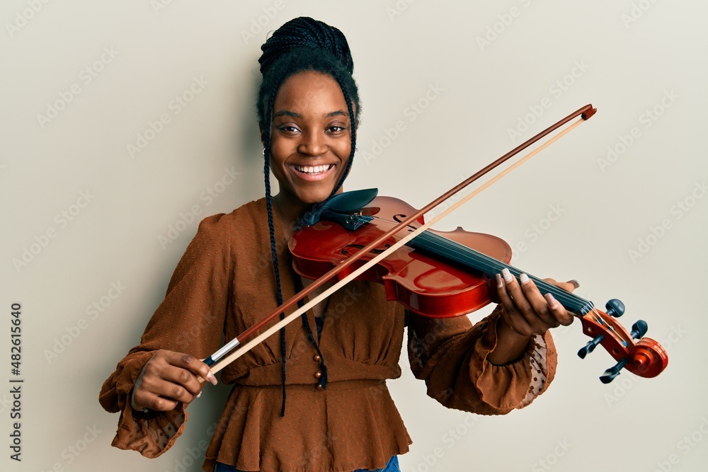 karakterisere indsprøjte Penneven African american woman with braided hair playing violin smiling and  laughing hard out loud because funny crazy joke. Stock Photo | Adobe Stock