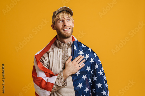 White military man with american flag holding hand on his chest