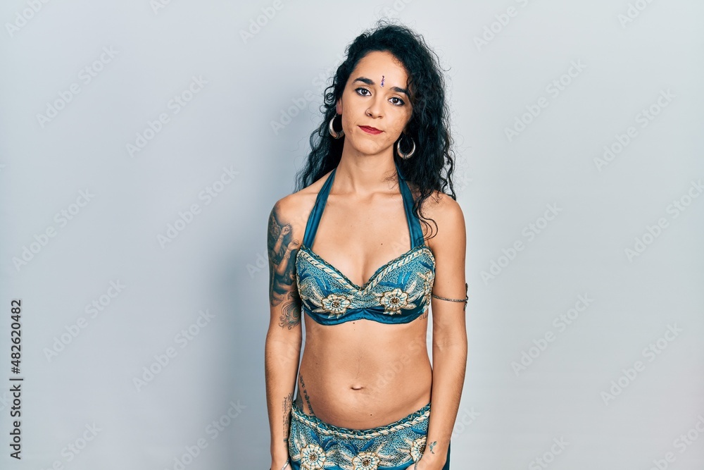 Young woman wearing bindi and traditional belly dance clothes looking sleepy and tired, exhausted for fatigue and hangover, lazy eyes in the morning. Young woman wearing bindi and traditional belly dance clothes looking sleepy and tired, exhausted for fatigue and hangover, lazy eyes in the morning.