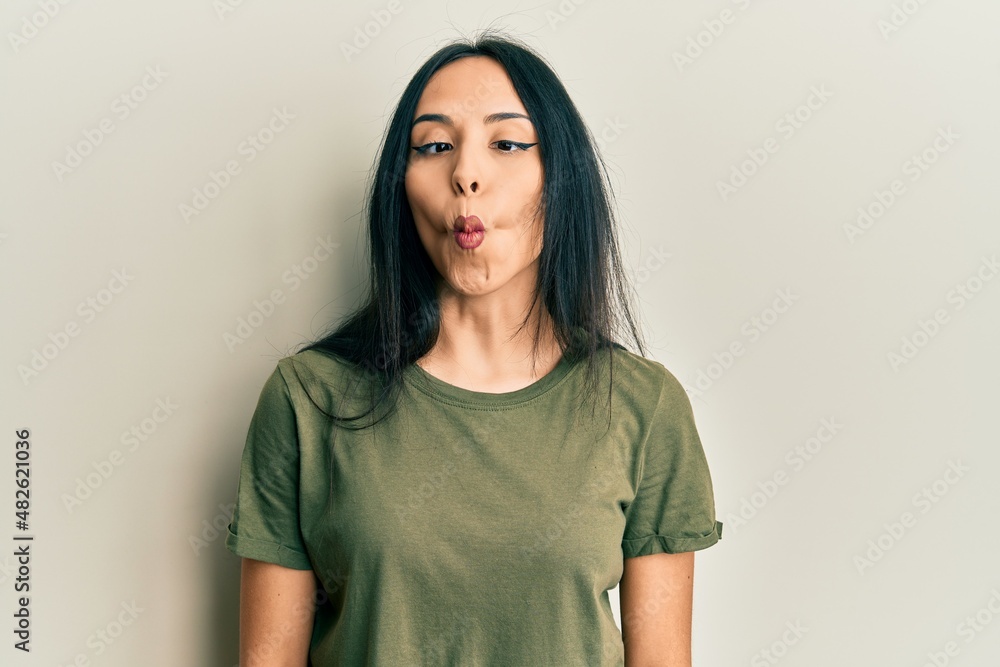 Young hispanic girl wearing casual t shirt making fish face with lips, crazy and comical gesture. funny expression. Young hispanic girl wearing casual t shirt making fish face with lips, crazy and comical gesture. funny expression.