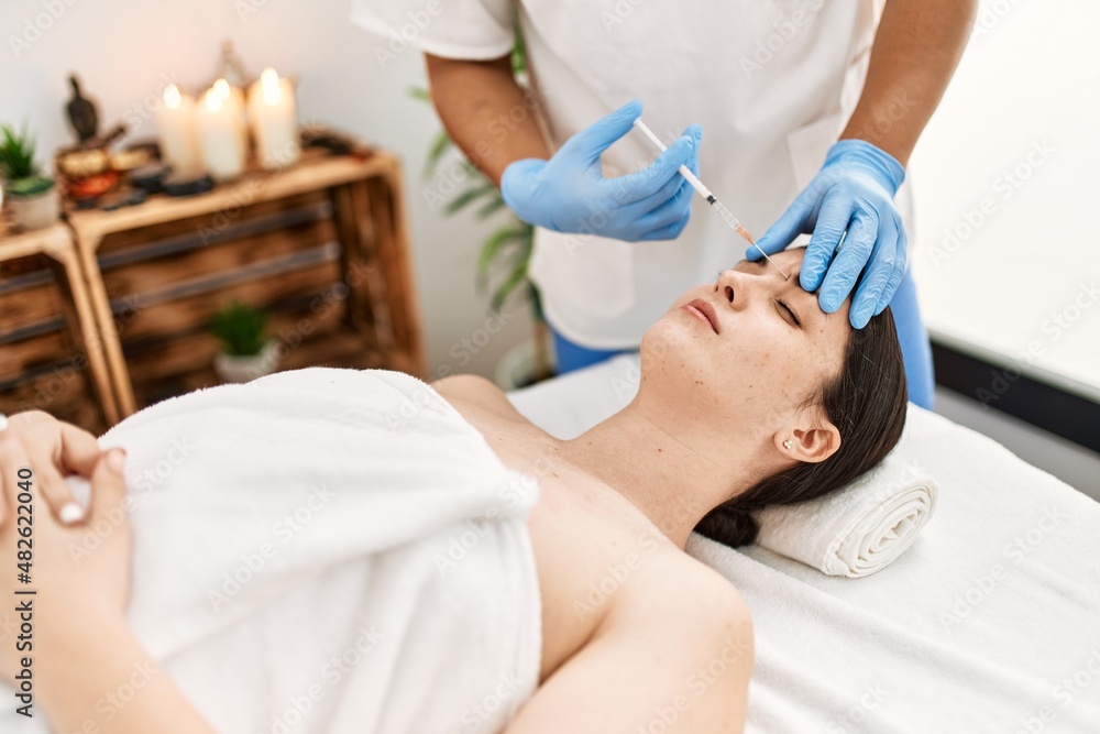 Doctor man injecting botox on woman face for anti aging treatment at the clinic.