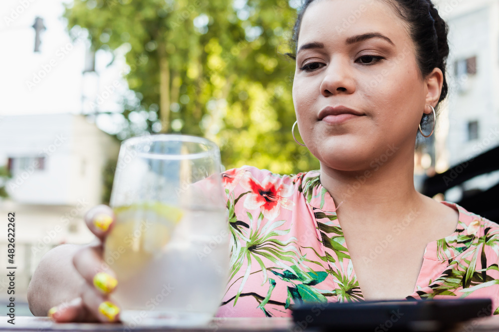 young woman enjoying outside a bar holding a shot of liquor that she is going to drink young woman enjoying outside a bar holding a shot of liquor that she is going to drink
