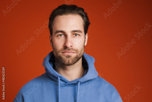 Young bristle man wearing hoodie posing and looking at camera