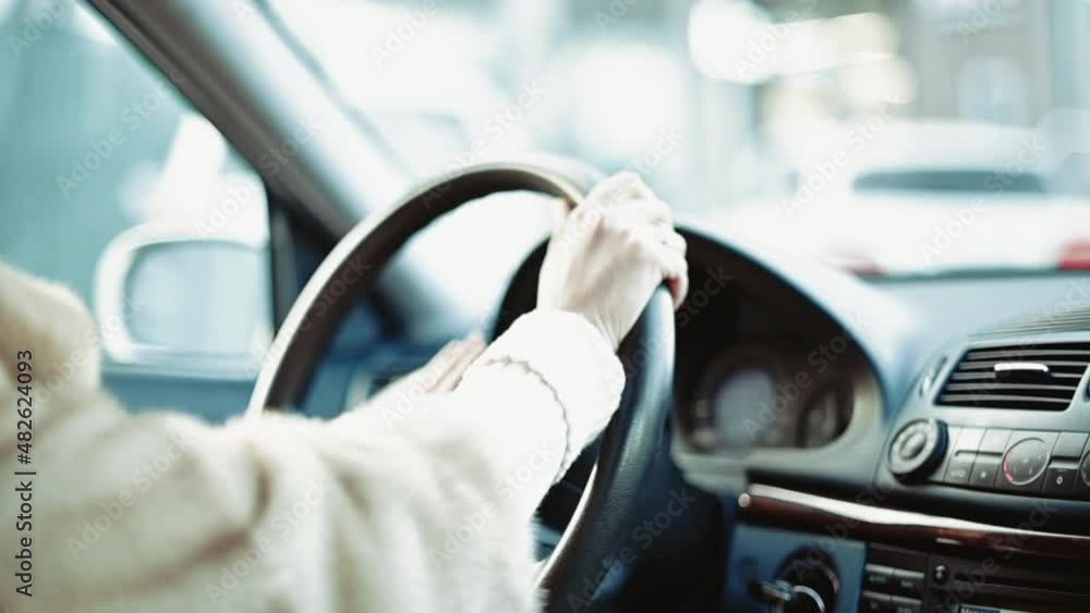 Woman driving a car in slow motion, hands on wheel Woman driving a car in slow motion, hands on wheel