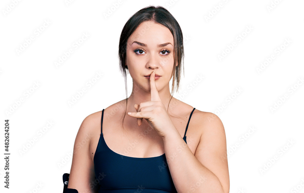 Young hispanic woman wearing sportswear asking to be quiet with finger on lips. silence and secret concept. Young hispanic woman wearing sportswear asking to be quiet with finger on lips. silence and secret concept.