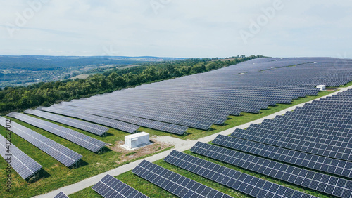 Large farm of industrial solar panels and generators built in a row in the field