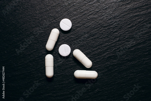 Tableau sur toile The concept of the sexual process of oral sex in the form of people from pills on a rough black background