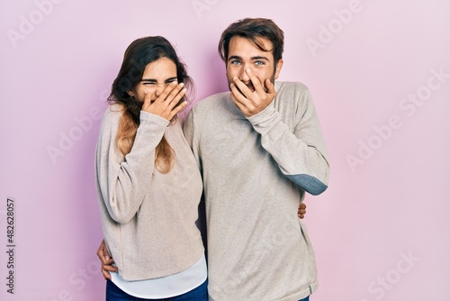 Schilderij op canvas Young hispanic couple wearing casual clothes laughing and embarrassed giggle cov